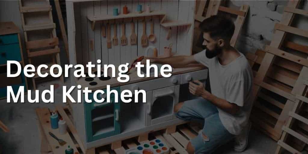 Photo of the man putting the finishing touches on the play kitchen. He's painting and adding hooks for utensils. The play kitchen, built from pallets, now clearly showcases areas like the sink, stove, and storage shelves.